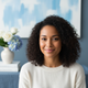 Smiling woman in her late 20s, headshot portrait, conveying comfort.